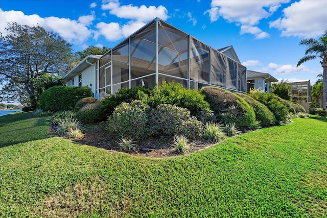 view of side of home featuring a lanai and a lawn