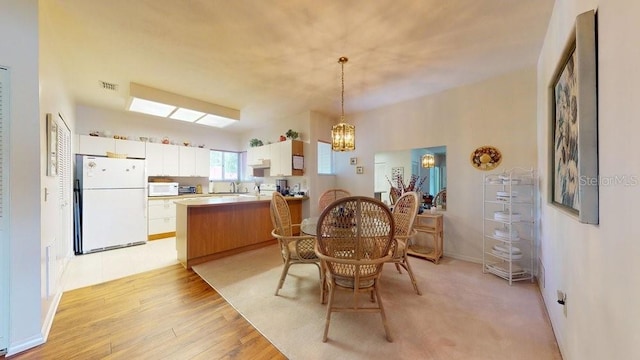 carpeted dining room with a notable chandelier