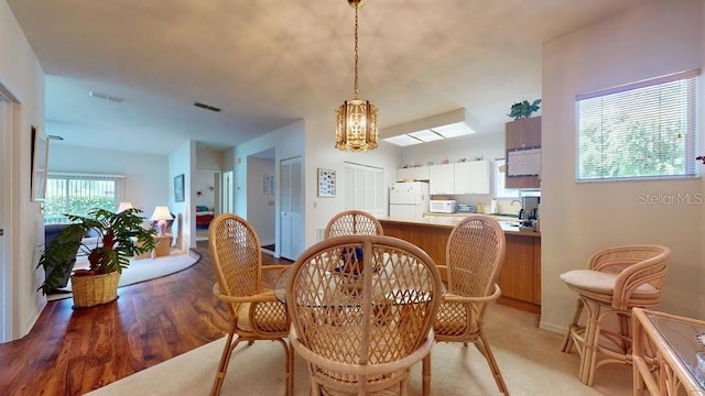 dining space featuring a notable chandelier and light hardwood / wood-style flooring