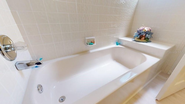 bathroom with a bath to relax in and tile walls