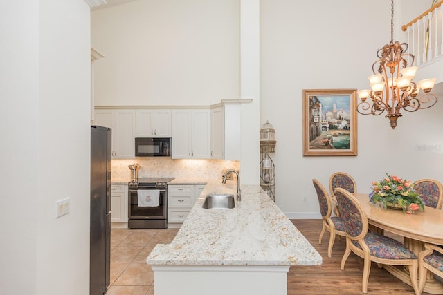 kitchen with tasteful backsplash, pendant lighting, a high ceiling, sink, and appliances with stainless steel finishes