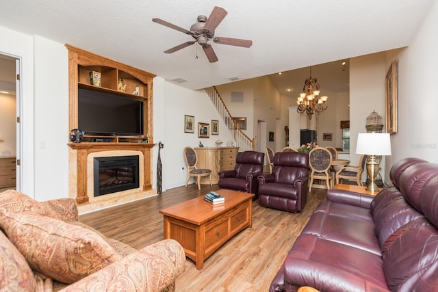 living room with a textured ceiling, ceiling fan with notable chandelier, and hardwood / wood-style floors