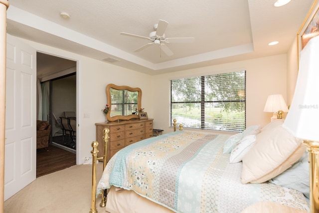 bedroom featuring ceiling fan, a raised ceiling, a closet, and hardwood / wood-style floors