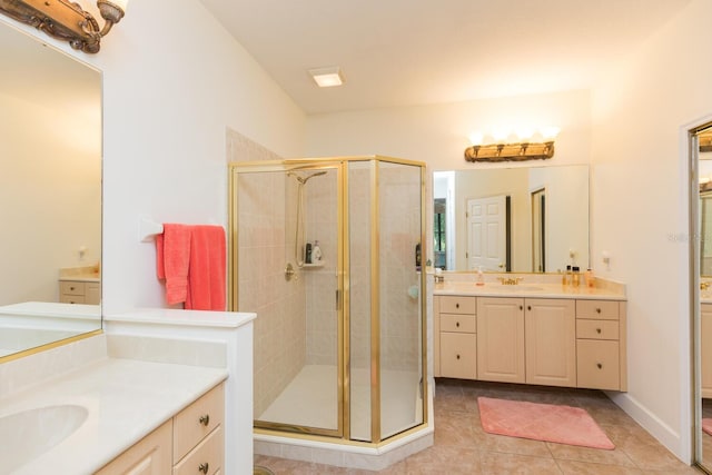 bathroom with dual sinks, a shower with door, tile floors, and large vanity
