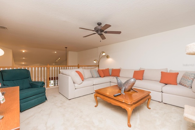 living room featuring ceiling fan, a textured ceiling, and light colored carpet