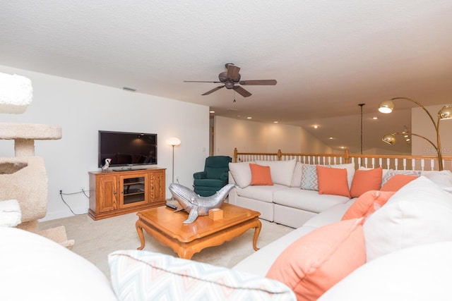 living room featuring ceiling fan, vaulted ceiling, a textured ceiling, and light carpet