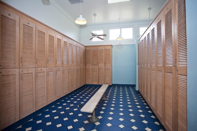 corridor with ornamental molding and dark tile flooring