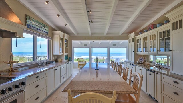 kitchen with a water view, sink, and light tile patterned floors