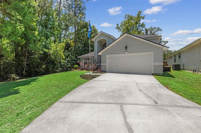 view of front facade featuring a front yard, a garage, and central air condition unit