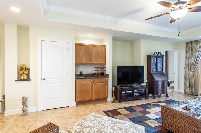 tiled living room with ornamental molding, ceiling fan, a tray ceiling, and sink