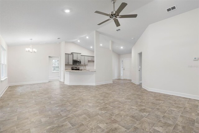 unfurnished living room with vaulted ceiling and ceiling fan with notable chandelier