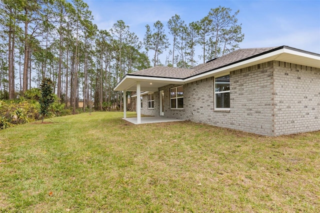 back of house with a yard and a patio