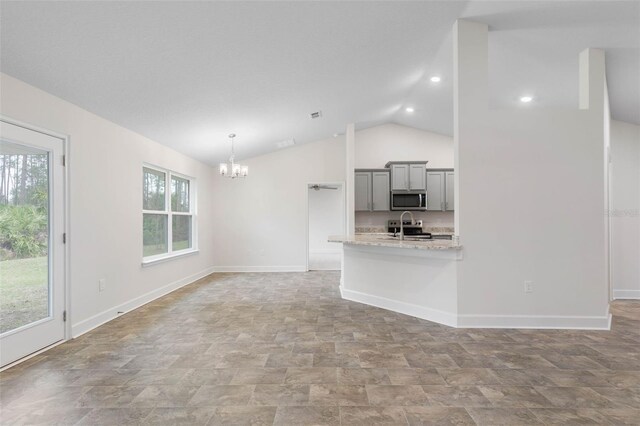 unfurnished living room with lofted ceiling and a chandelier