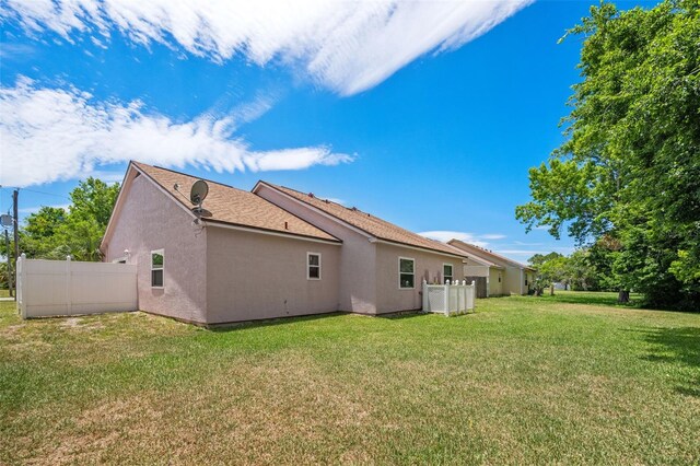 rear view of house featuring a yard