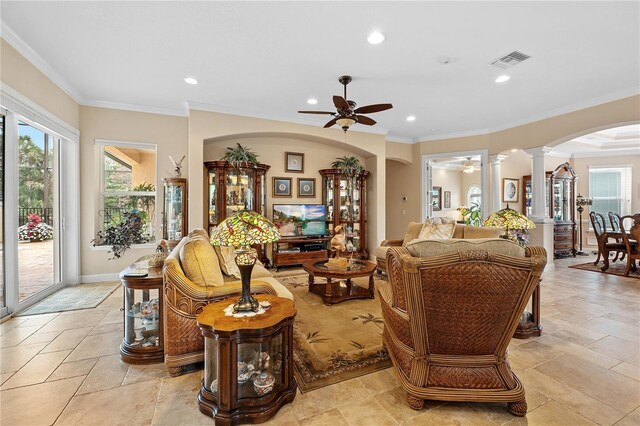 tiled living room featuring ceiling fan, decorative columns, and ornamental molding