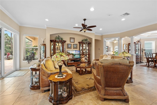 living room with arched walkways, ceiling fan, visible vents, ornate columns, and crown molding