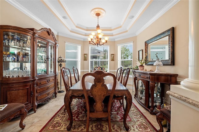 tiled dining space with a tray ceiling, ornate columns, crown molding, and a notable chandelier