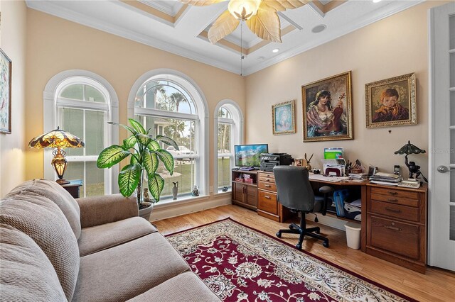 office with light hardwood / wood-style floors, a wealth of natural light, coffered ceiling, and ornamental molding