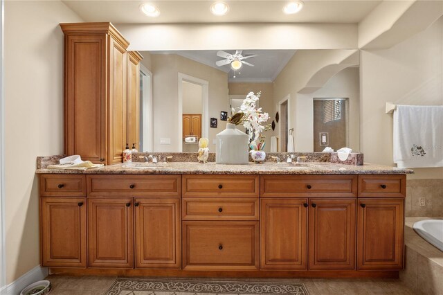 bathroom featuring ceiling fan, tile flooring, tiled tub, and double sink vanity