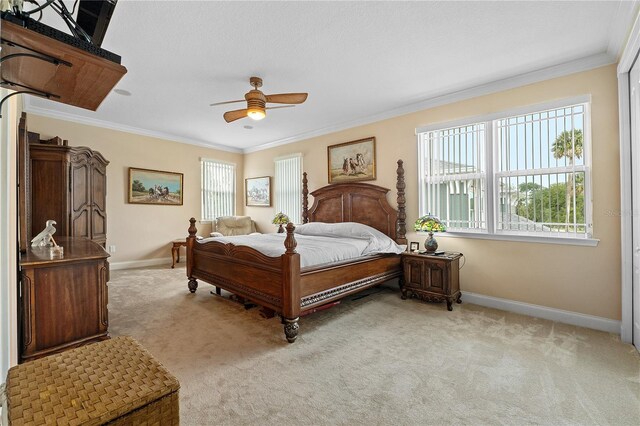 carpeted bedroom featuring ornamental molding and ceiling fan