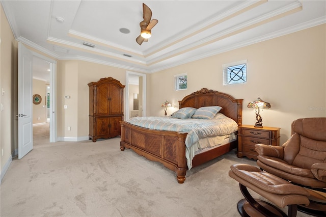 carpeted bedroom with ceiling fan, a tray ceiling, and crown molding