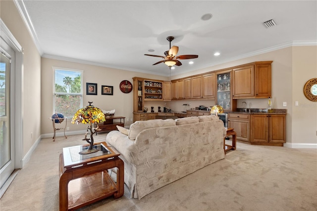 carpeted living room with ceiling fan, sink, and ornamental molding