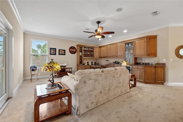 living area featuring crown molding, light colored carpet, visible vents, ceiling fan, and baseboards