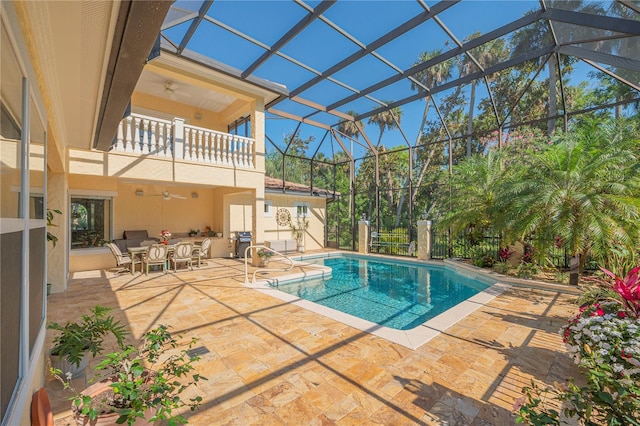 view of swimming pool featuring a patio, a lanai, area for grilling, and ceiling fan