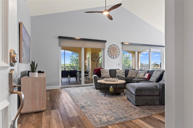 living room with hardwood / wood-style floors, high vaulted ceiling, and ceiling fan