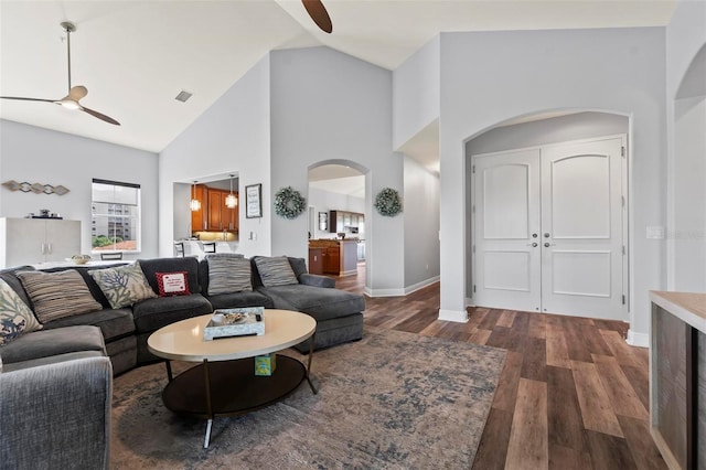 living room with high vaulted ceiling, ceiling fan, and dark wood-type flooring