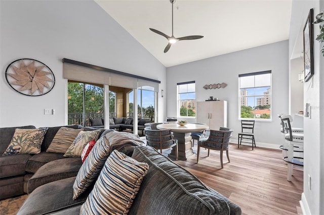 living room with high vaulted ceiling, ceiling fan, and light hardwood / wood-style floors