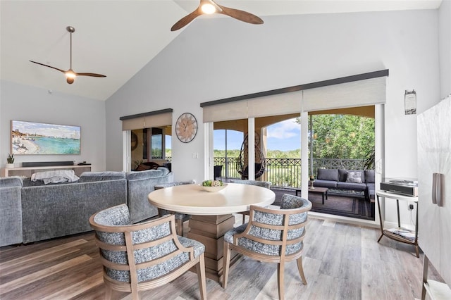 dining area with high vaulted ceiling, ceiling fan, and hardwood / wood-style floors