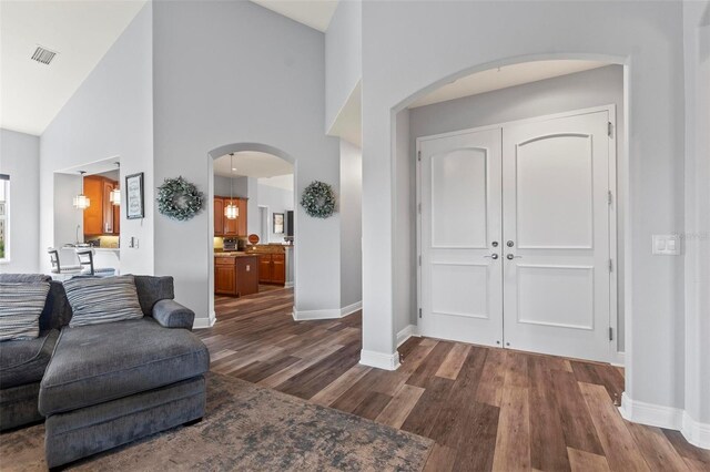 living room with high vaulted ceiling and dark hardwood / wood-style flooring