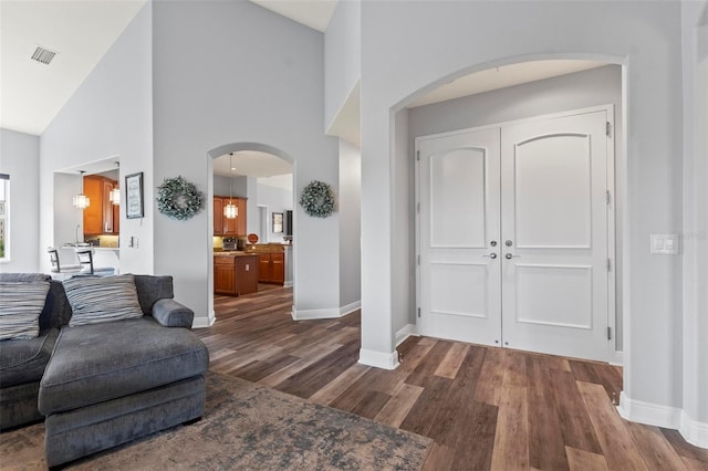 entrance foyer featuring dark wood-type flooring and high vaulted ceiling