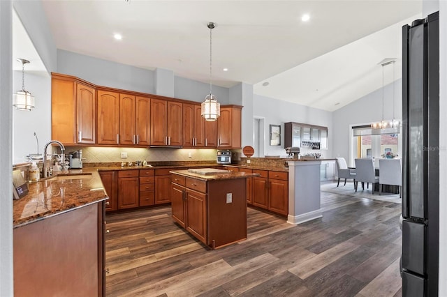 kitchen with kitchen peninsula, decorative light fixtures, a kitchen island, sink, and decorative backsplash