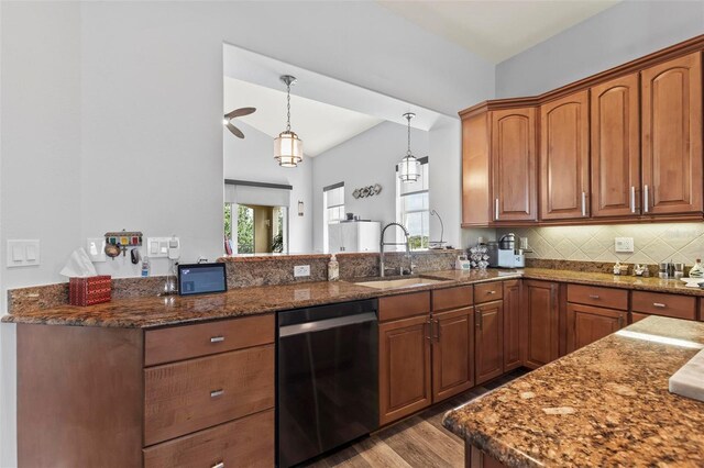 kitchen featuring stainless steel dishwasher, hardwood / wood-style floors, decorative light fixtures, sink, and tasteful backsplash