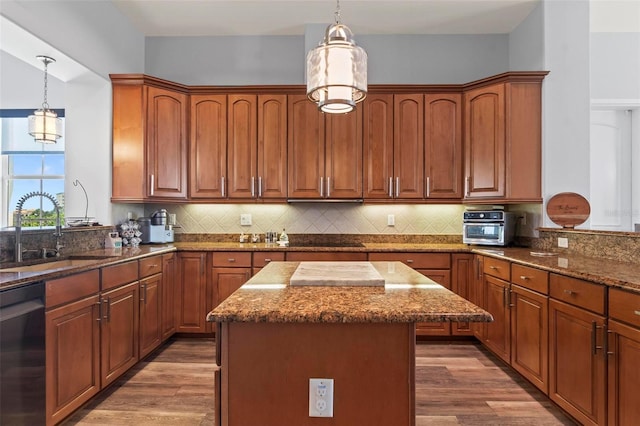 kitchen featuring sink, a kitchen island, black dishwasher, and hanging light fixtures