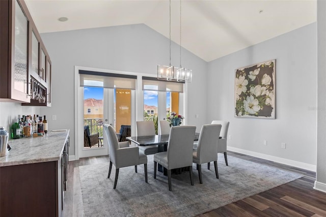 dining room with lofted ceiling, an inviting chandelier, and dark hardwood / wood-style flooring