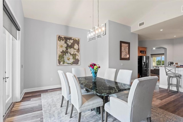 dining room featuring vaulted ceiling and wood-type flooring