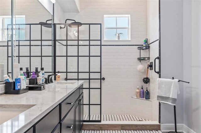 bathroom featuring dual vanity and an enclosed shower