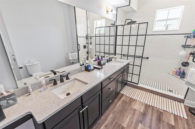 bathroom featuring hardwood / wood-style floors, a shower with door, dual sinks, and large vanity