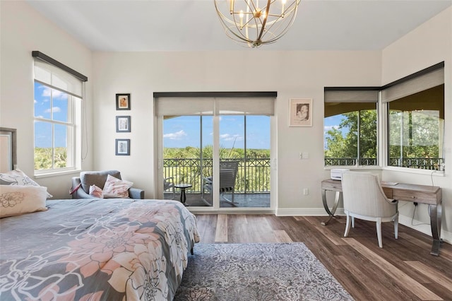 bedroom with dark hardwood / wood-style floors, access to outside, and a chandelier