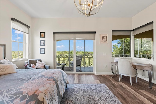 bedroom with access to exterior, dark wood-type flooring, and a chandelier