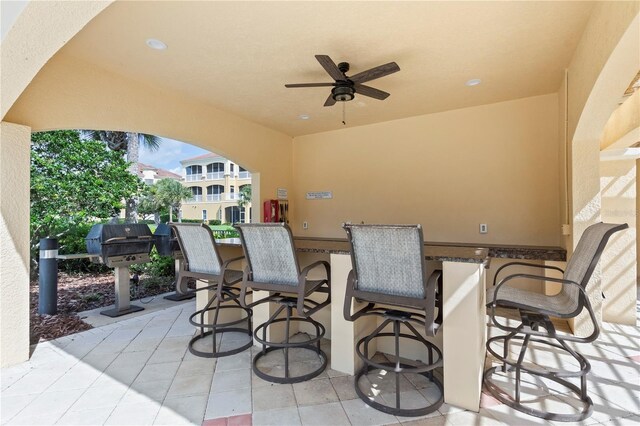 view of patio / terrace with a grill, exterior bar, and ceiling fan