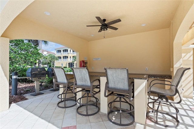 view of patio featuring an outdoor bar, ceiling fan, and area for grilling