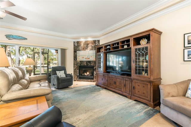 tiled living room with a high end fireplace, ceiling fan, and crown molding