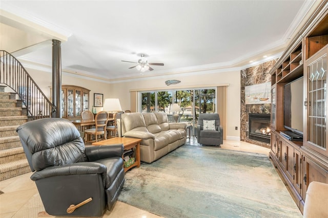 tiled living room featuring ceiling fan, a fireplace, and crown molding