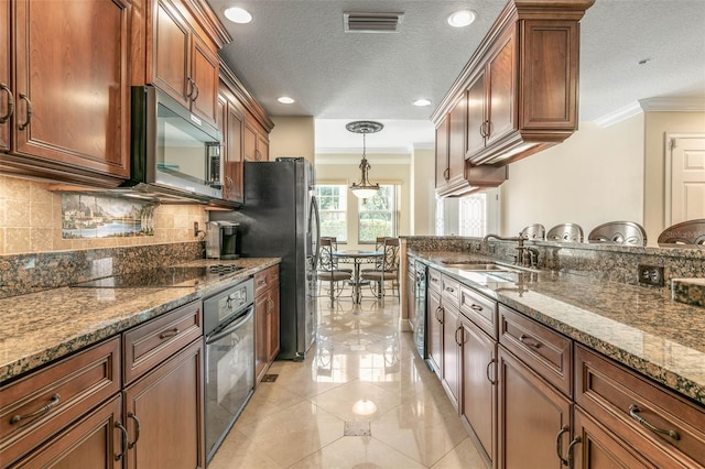 kitchen with black appliances, dark stone countertops, ornamental molding, and sink