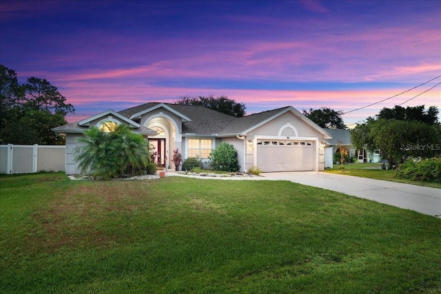 ranch-style house featuring a lawn and a garage