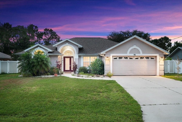 single story home featuring a yard and a garage